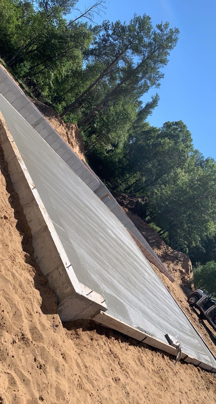 Concrete slab and forms beside wooded property